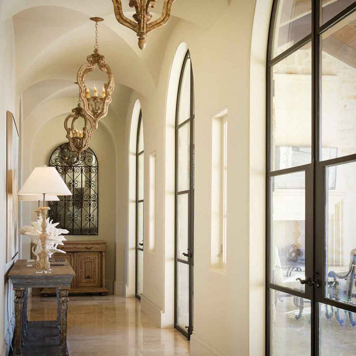 This California Spanish style home features a beautiful Groin Vault Ceiling flanked by arched doors and accented with wrought iron details
