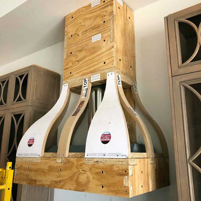 A custom range hood framing kit being installed during home remodel house flip